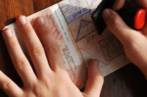 a person stamping an open passport, immigration