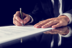 man signing a legal document